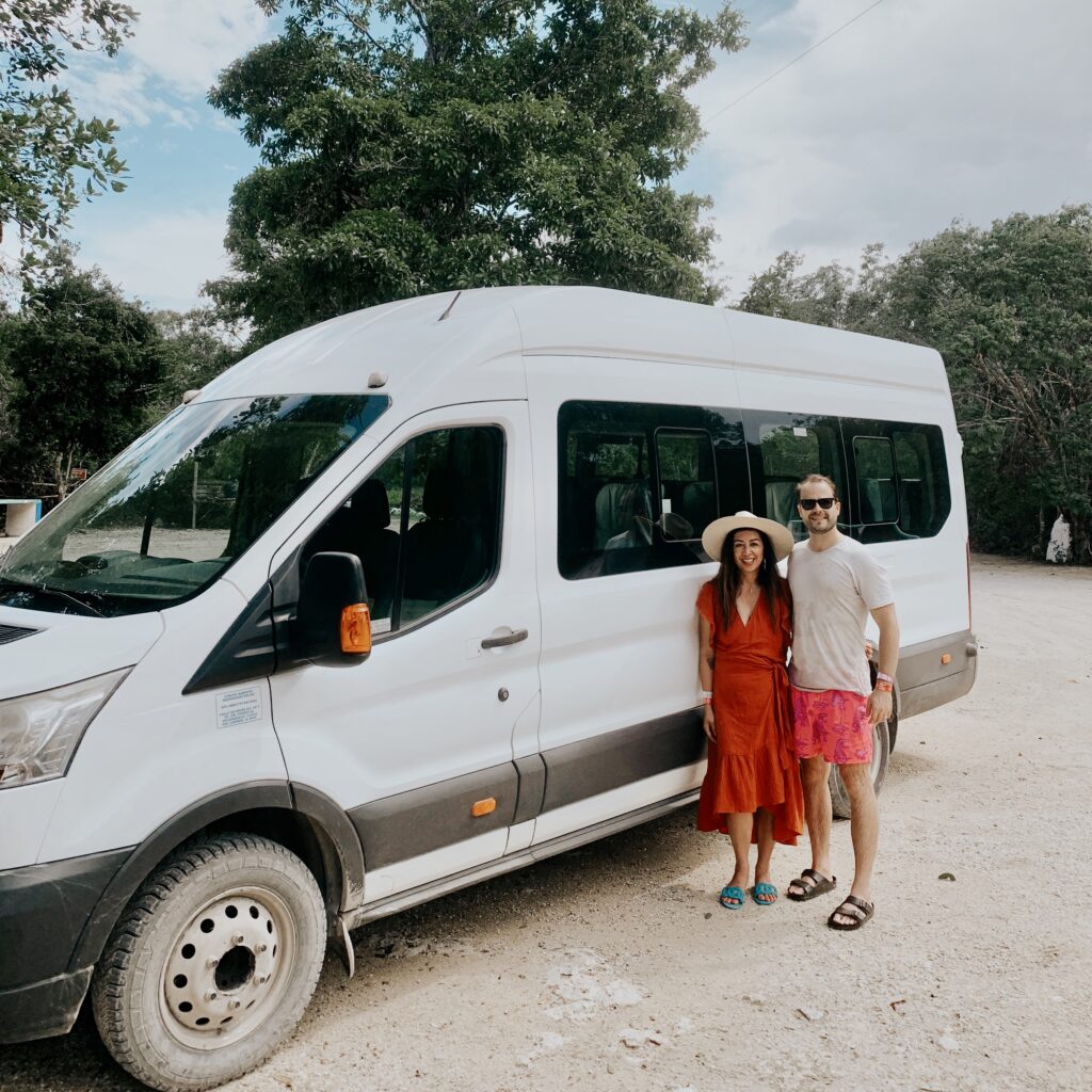 Couple standing beside their private transportation van in Tulum