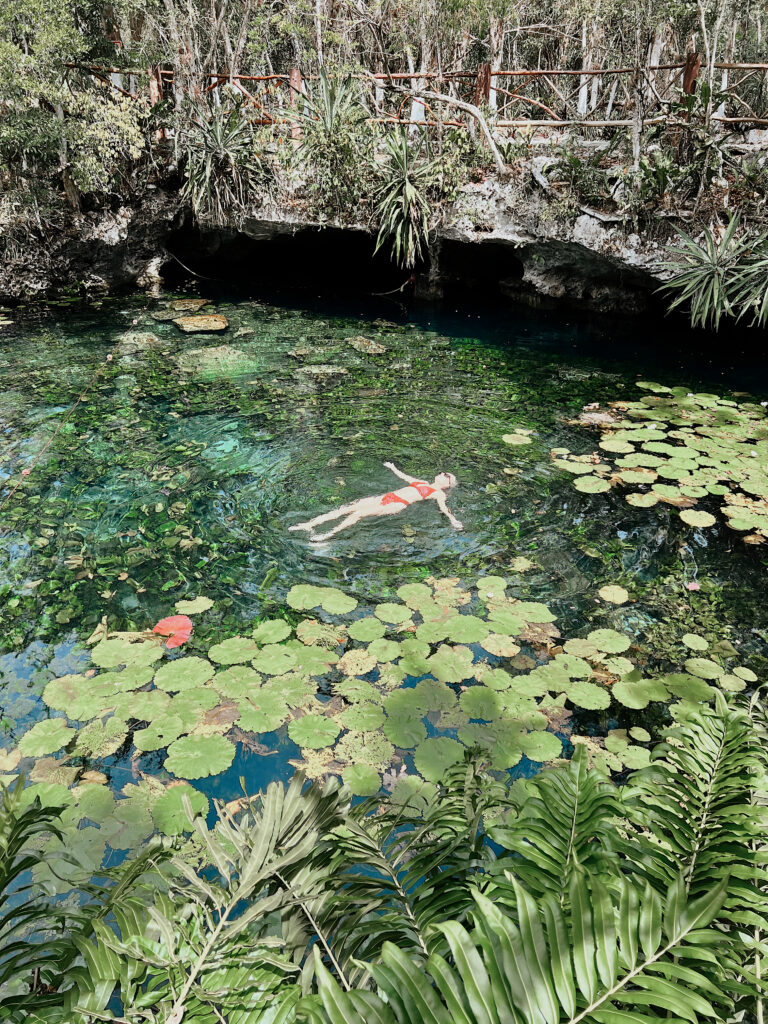 Luxury Tulum getaway: Woman floats in a serene cenote, a private transportation experience.