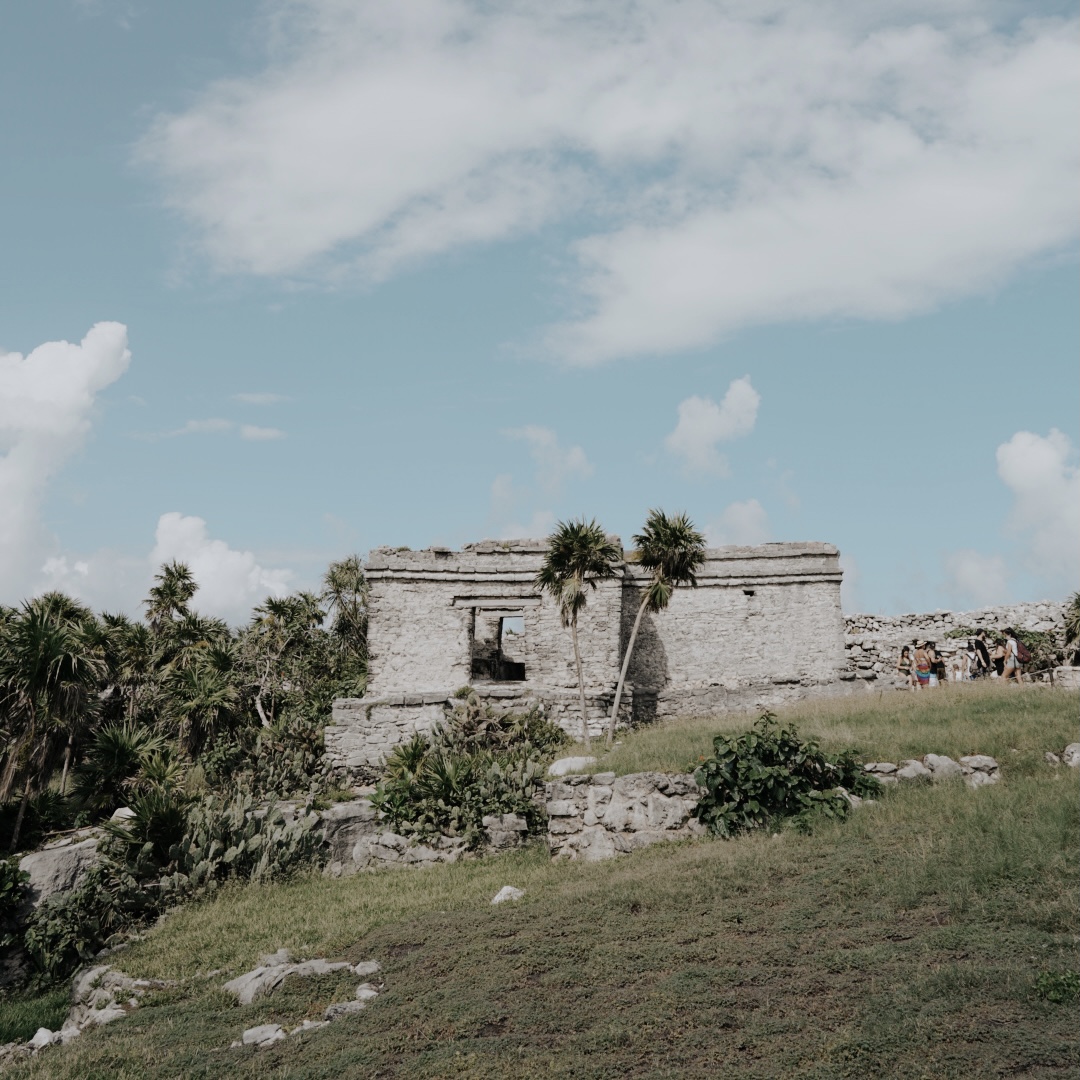 Tulum Ruins framed by palm trees beside the Caribbean Sea