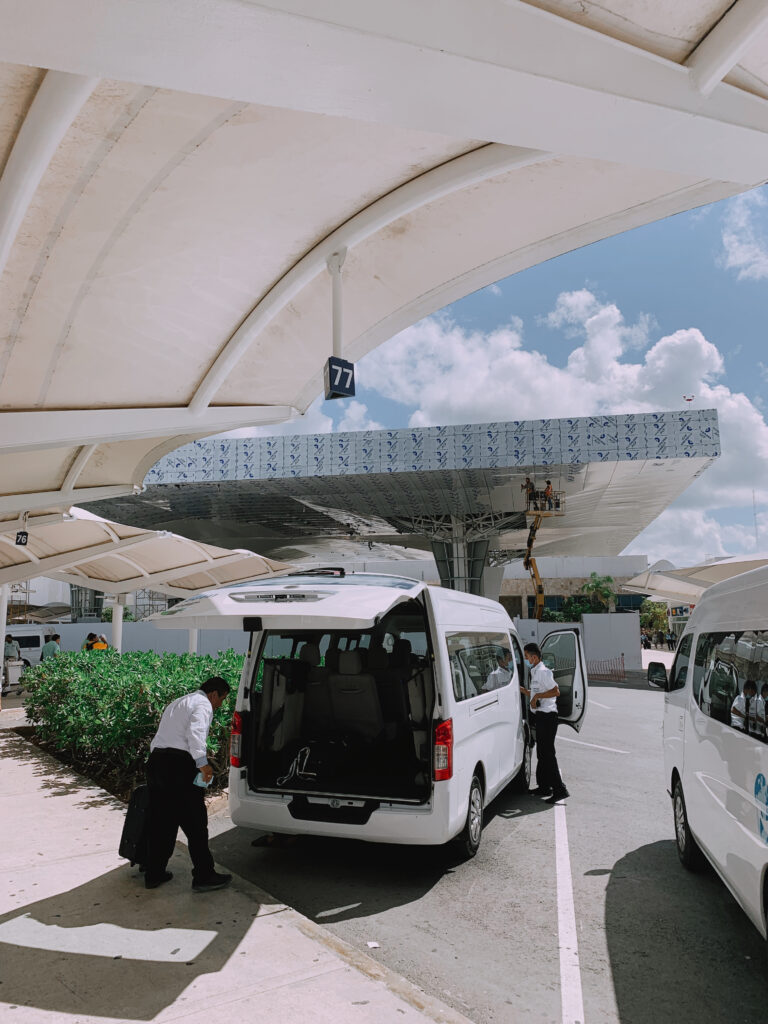 Transportation team loading luggage into a private van at Cancun Airport
