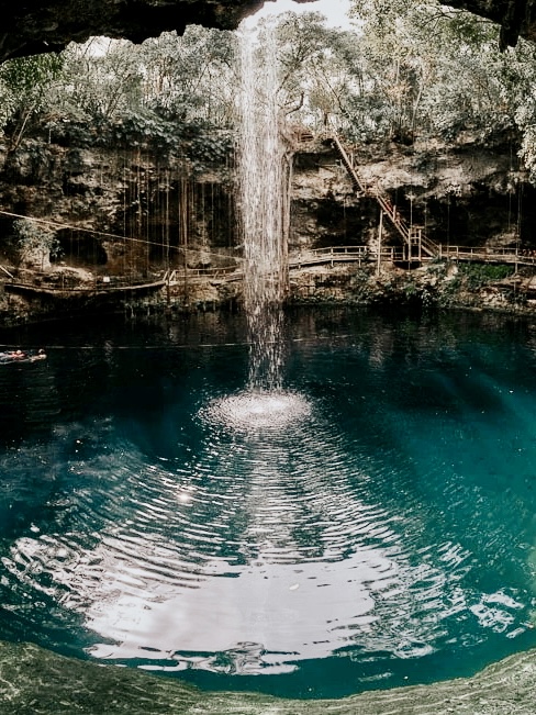 Guest swimming in the open jungle setting of X’Canché Cenote