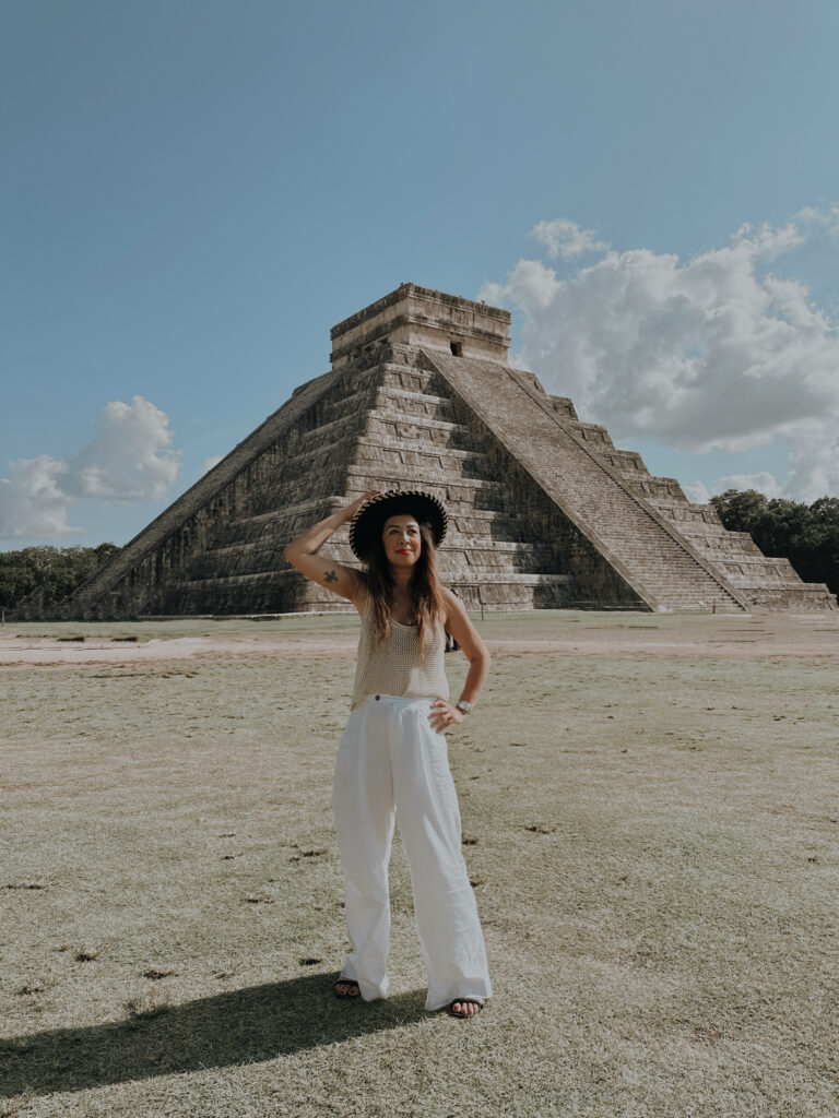 Luxury Tulum travel: Woman at Chichen Itza pyramid, a must-see historical site.