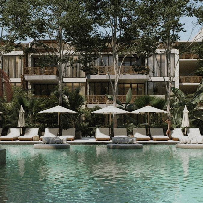 Luxury Tulum accommodations: resort pool with lounge chairs and lush tropical foliage