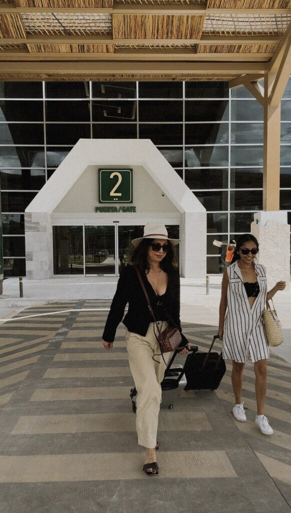 Women with luggage at the Tulum airport, ready for a refined getaway.