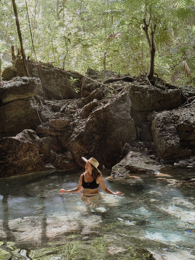 Woman swimming in a semi closed cenote in Chemuyil