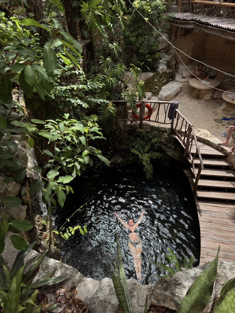 Woman relaxing in a natural cenote in Tulum, a Go Tulum Travel experience.