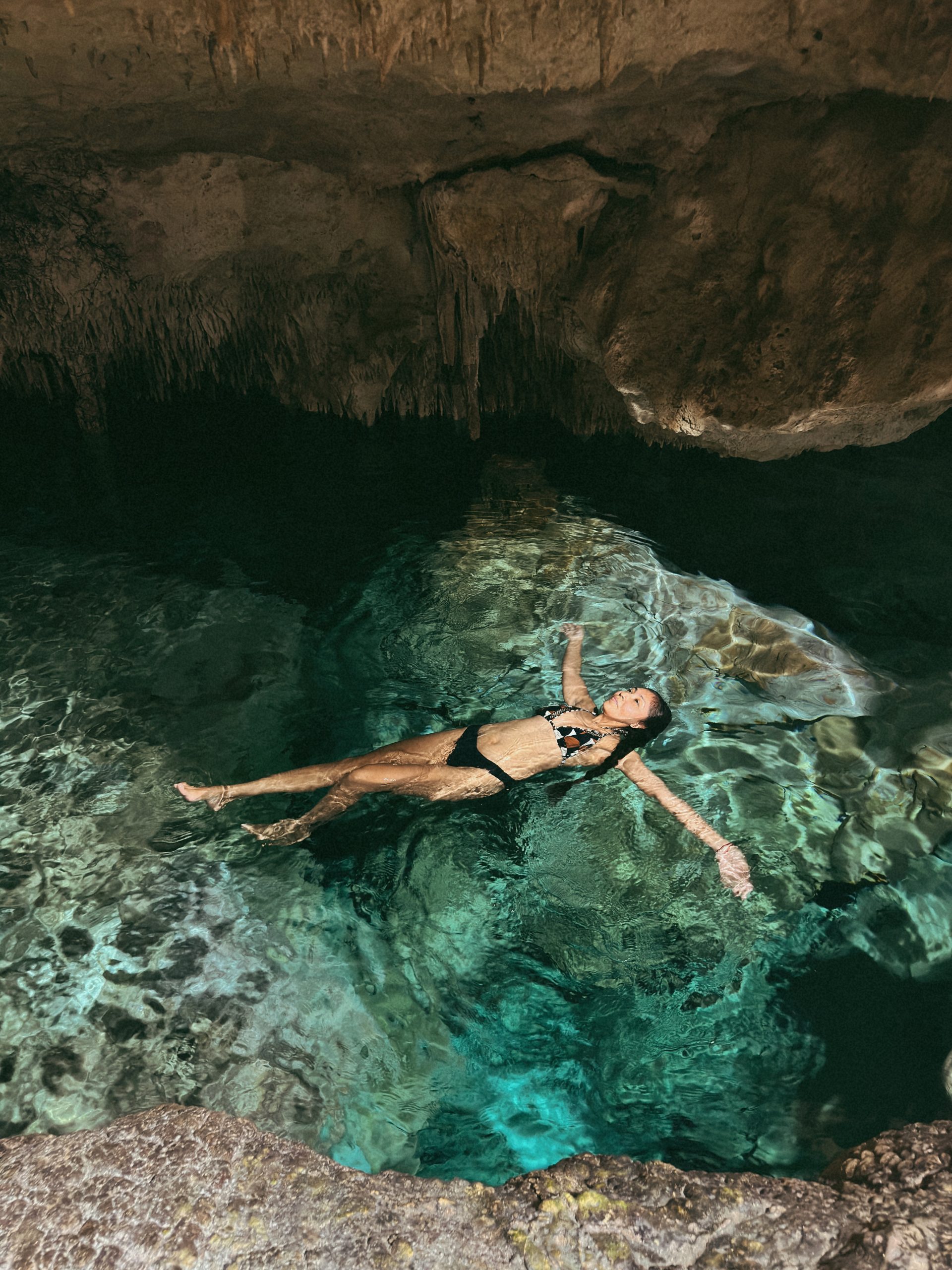 Woman swimming inside Taak Bi Ha Cenote near Tulum